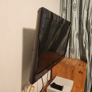 טלוויזיה מותקנת על קיר ליד וילון