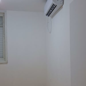 מזגן מותקן על קיר לבן בחדר ריק