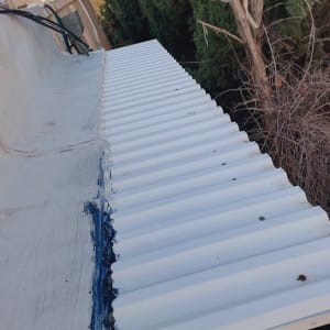 איטום גג עם חומר כחול בין לוחות מתכת