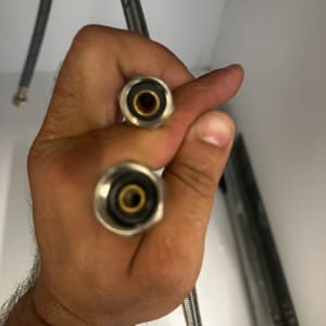 יד מחזיקה שני צינורות מתכת עם חיבורים