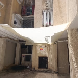 סוכך בד מתוח בין עמודים במבנה חיצוני