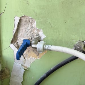 ברז מים מותקן על קיר עם צינור מחובר