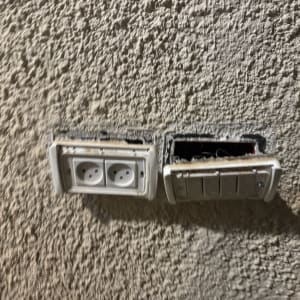 שקע חשמל כפול וקופסת חיבורים פתוחה בקיר