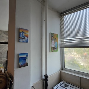 תנור גז קטן ליד חלון עם תריסים ותמונות על הקיר