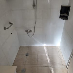 חדר אמבטיה עם אריחים, מקלחון וברזים