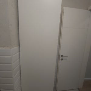 ארון לבן מותקן ליד דלת בחדר