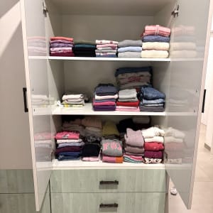 בגדים מקופלים בארון פתוח עם מדפים