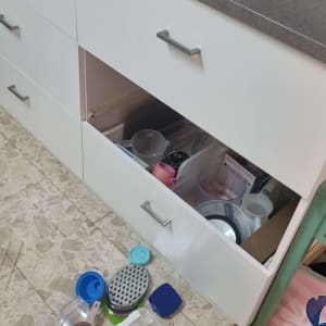 מטבח עם מגירה פתוחה וכלי פלסטיק על הרצפה