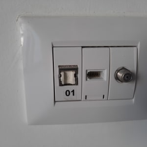 שקע רשת עם חיבורי תקשורת שונים על קיר