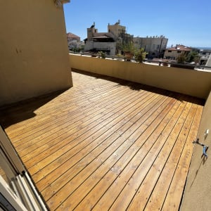 מרפסת עץ עם עציצים על המעקה