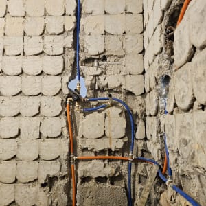 צינורות כחולים וכתומים בקיר במהלך שיפוץ