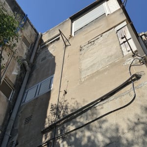 חזית בניין מגורים ישן עם צנרת אינסטלציה וצינורות ניקוז חיצוניים בגובה