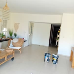 פחי צבע בסלון מרוהט במהלך עבודת צביעת דירה