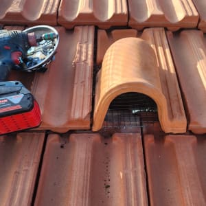 כלי עבודה על גג רעפים עם רשת למניעת יונים