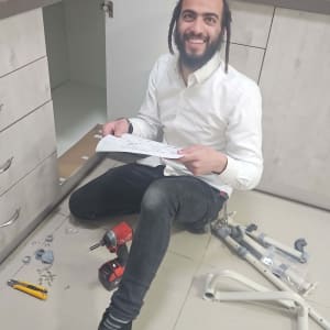 אדם מתקין ארון מטבח עם כלים וחלקים