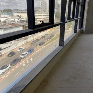 חלון גדול עם סימני לכלוך, נוף עירוני בחוץ