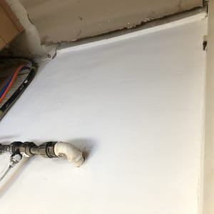 קיר צבוע בלבן עם צינורות חשופים