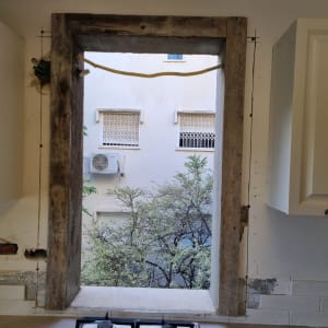 חלון ללא זכוכית עם מסגרת עץ חשופה ושקעי חשמל פתוחים