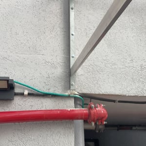 צינור אדום וקיר עם חיבורי מתכת