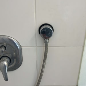 ברז ומקלחת על קיר אריחים לבנים