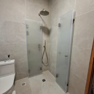 מקלחת עם דלתות זכוכית ושירותים