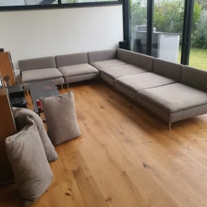 ספה אפורה גדולה בחדר עם רצפת עץ