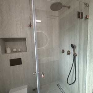 מקלחת מודרנית עם דלת זכוכית וברזים מעוצבים