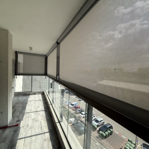 מרפסת עם סוככים שקופים ומעקה זכוכית