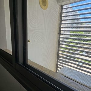 חלון עם רשת ומרפסת עם תריסים