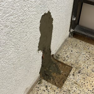 תיקון קיר עם טיח על רצפת אריחים