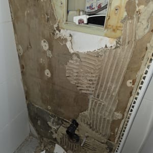 קיר חשוף עם צנרת ותשתית אינסטלציה