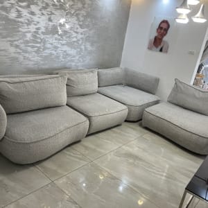 ספה אפורה בחדר מגורים עם קיר מעוצב