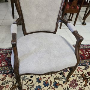 כיסא מרופד בבד אפור עם מסגרת עץ כהה