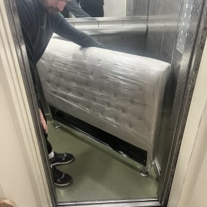 אדם מעביר רהיט עטוף במעלית