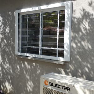 חלון אלומיניום עם תריסים על קיר חיצוני