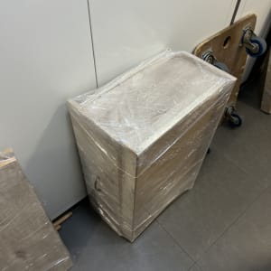 רהיט עץ עטוף בניילון נצמד להגנה לצד עגלת הובלות