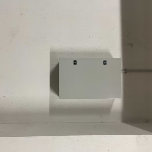 ארון חשמל אפור מותקן על קיר בטון