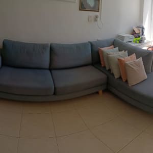 ספה אפורה עם כריות צבעוניות בסלון מואר