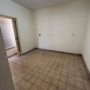 חדר ריק עם רצפת אריחים ודלת פתוחה