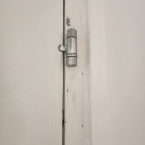 תמונה של מנעול על דלת לבנה