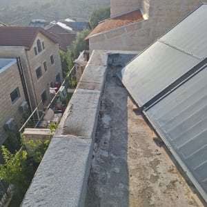 גג עם עבודת איטום ושמשות סולאריות