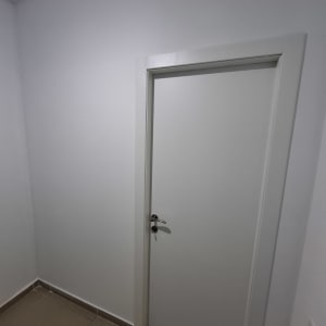 דלת לבנה עם ידית כסופה על קיר גבס