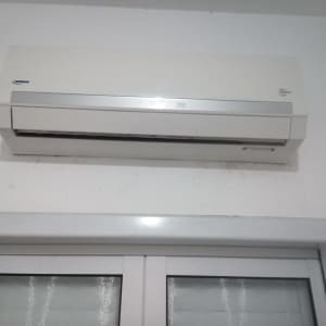 מזגן קיר לבן מותקן מעל חלון