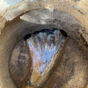 תמונה של צינור חלוד עם מים זורמים