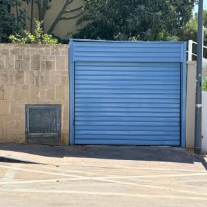 שער חשמלי כחול ליד קיר אבן
