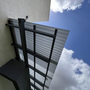 גג מתכת עם קורות תמיכה בשמיים בהירים