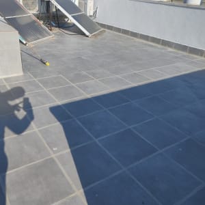 גג עם אריחים אטומים, דודי שמש וצינורות.