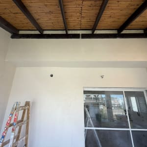 תקרה מעץ עם קיר לבן וסולם בחדר ריק