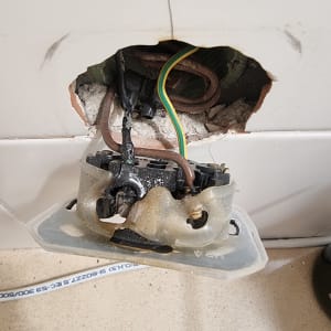 שקע חשמלי פגום עם חוטים חשופים בקיר