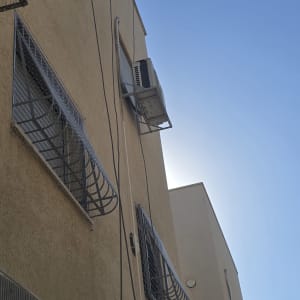 בניין עם מזגנים ורשתות על החלונות